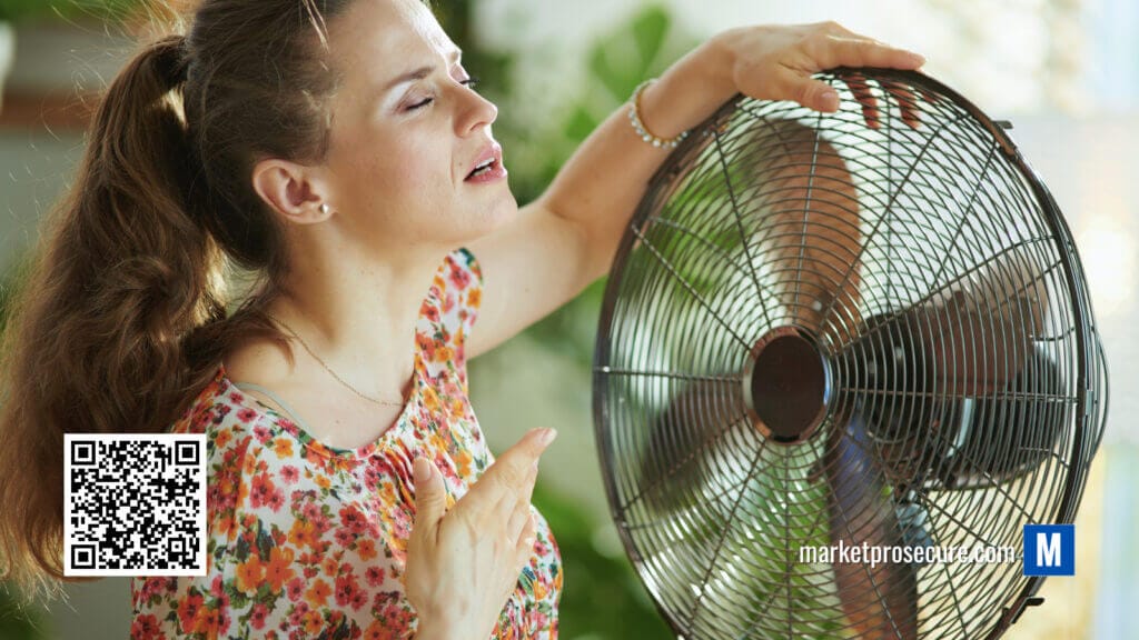 A woman is using a fan to cool herself during a heatwave.